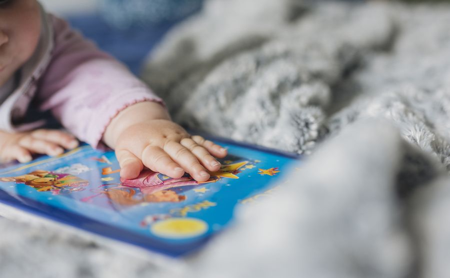 bébé posant sa main sur un livre